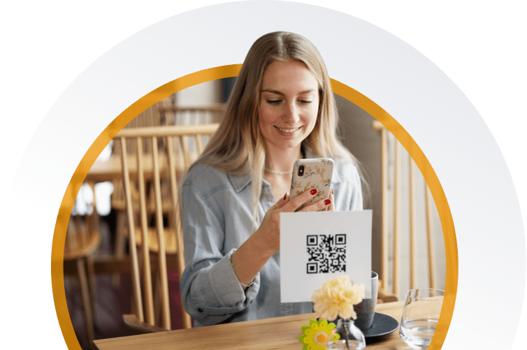 Restaurant guest scanning a QR code on the table to open a digital menu on a smartphone